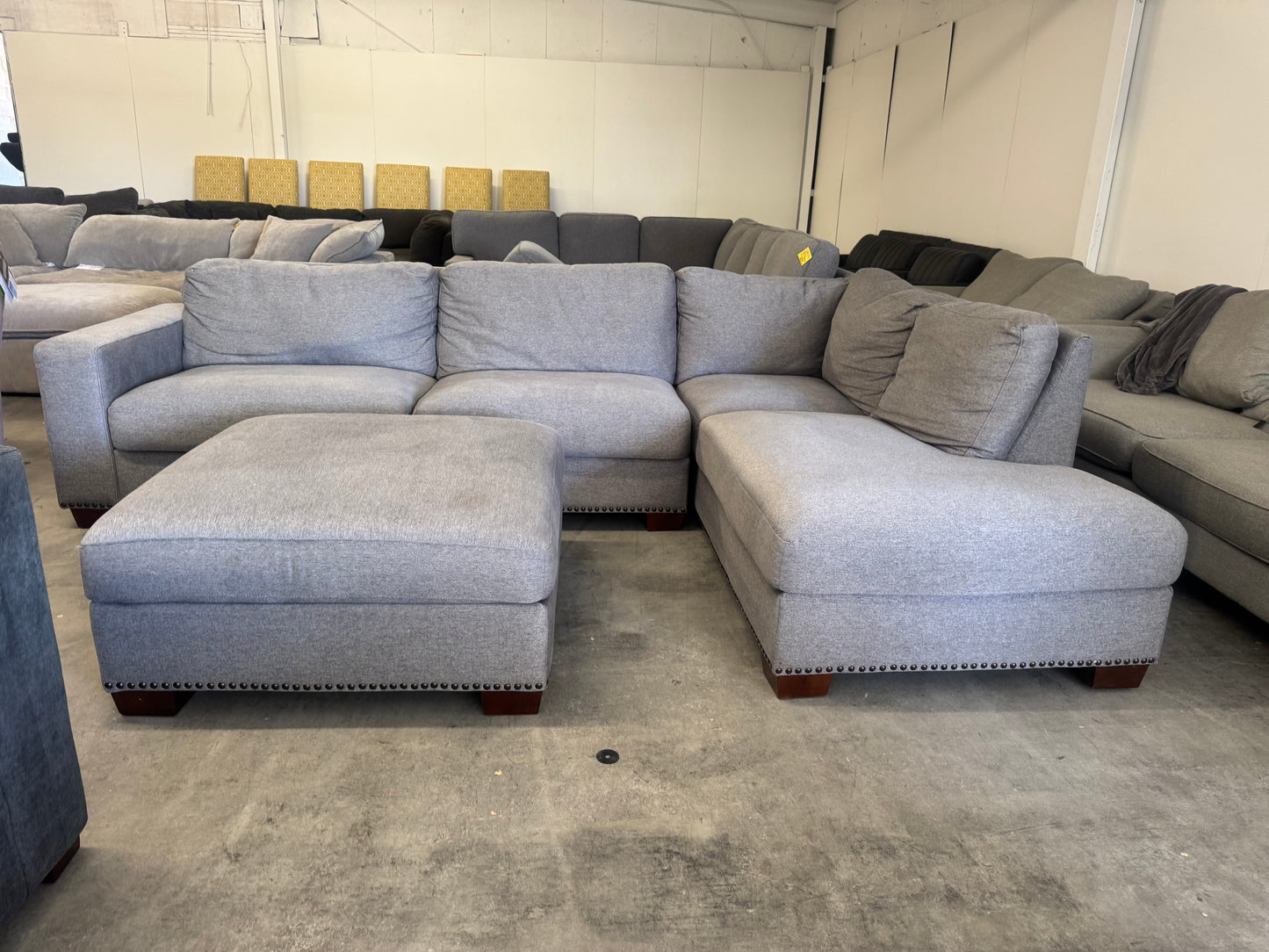 Gray L Shape Sofa with Ornate Trim and Ottoman