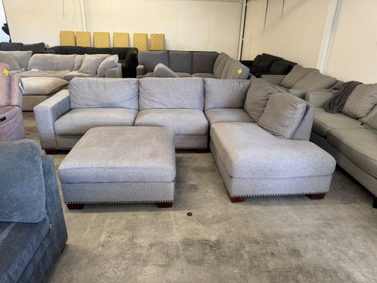 Gray L Shape Sofa with Ornate Trim and Ottoman